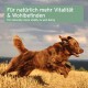 Ein brauner Hund, der fröhlich durch ein Feld läuft, mit Textüberlagerung in Deutsch und Englisch, der natürliche Vitalität und Wohlbefinden fördert.