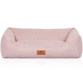 Helle rosa Hundebett mit plüschigem Design und einem braunen Lederetikett mit einem Hundesilhouette, beschriftet mit "KNUFFELWUFF."