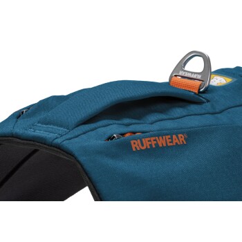 Eine Nahaufnahme eines blauen Hundegeschirrs mit dem Markennamen "RUFFWEAR" in Orange, mit einem Metallbefestigungspunkt und Reißverschlussdetails.