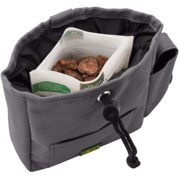Eine graue Leckerlitasche für Haustiere mit einem Kordelzugverschluss, die ein Paket Leckerlis und sichtbare Stücke von Hundesnacks enthält.