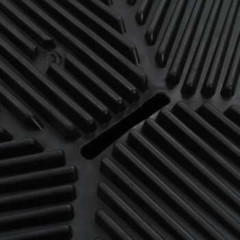 Nahaufnahme einer strukturierten schwarzen Gummimatte mit erhöhten Rillen und einem zentralen Schlitz, entworfen für die Verwendung mit Haustieren.