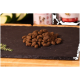 Haufen brauner trockener Hundefutter-Kroketten auf einer schwarzen Schiefertafel mit unscharfen Tierfutterbehältern im Hintergrund.