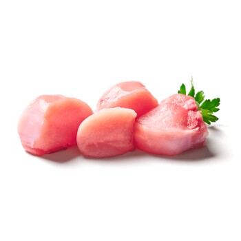 Rohe rosa Hähnchenstücke mit Petersilienzweig auf weißem Hintergrund, Tierfutterprodukt.