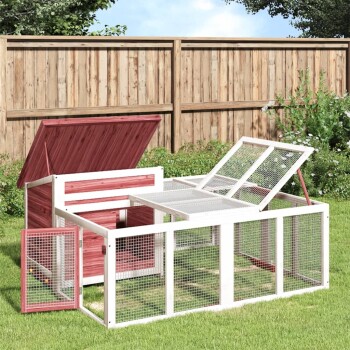 Außenbereich für Haustiere mit einem Holzhaus mit rotem Dach und weißem Netzzaun, im Grasgarten platziert.