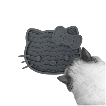 Eine graue Silikon-Futtermatte für Katzen in Form von Hello Kitty, mit gewellten Linien und einer Schleife, mit dem Kopf einer Katze im Vordergrund.