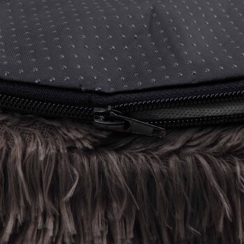 Nahaufnahme eines Haustierbettes mit einem Reißverschluss, strukturiertem schwarzen Oberteil und einem flauschigen grauen Unterteil.