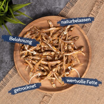 Getrocknete Fischleckereien auf einem Holztablett, beschriftet mit "Belohnung", "naturbelassen", "getrocknet" und "wertvolle Fette."