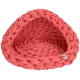 Un lit pour animaux de compagnie confortable de couleur corail avec un design tressé, présentant une forme douce et arrondie et une petite étiquette sur le côté.