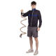 Eine Person in einer marineblauen Zip-Jacke und grauen Shorts hält ein buntes geflochtenes Hundespielzeug, das seine spiralförmige Form zeigt.