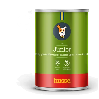 Grüne Dose Husse Junior Welpenpastete mit Kalbfleisch, gekennzeichnet für Welpen bis zu 12 Monaten, mit Immunitätsunterstützung und ohne künstliche Aromen.