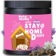 Behälter von 'BeG buddy Stay@Home Drops' für Haustiere, mit einem schlafenden Welpen, einem Hundehäuschen und floralen Akzenten auf einem rosa Hintergrund.