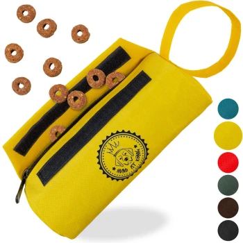 Gelbe Leckerlitasche mit Reißverschluss, mit einem Hundelogo, gefüllt mit runden Hundeleckerlis und umgeben von verstreuten Leckerlis.