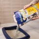 Eine Person gießt Biokats Classic 3in1 Katzenstreu aus einer blauen Tüte in eine dunkelblaue Katzentoilette, vor einem hellen gefliesten Hintergrund.