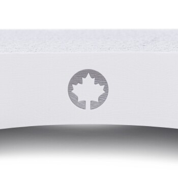 Weiches Haustierbett mit einer strukturierten Oberfläche und einem runden Logo mit einem stilisierten Ahornblatt.