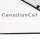 Nahaufnahme einer Haustiermatte mit dem Text 'CanadianCat' in fetten grauen Buchstaben auf einem weißen Hintergrund mit einem schwarzen Rand.