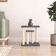 Eine getigerte Katze sitzt auf einem zweistufigen Katzenbaum mit einem dunkelgrauen oberen Teil und beigen Pfosten, der in einem modernen Wohnzimmer platziert ist.