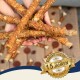 Hände halten mehrere lange, kaubare Hundeleckerlis mit einem Abzeichen, das 'Beste Qualität' und '15 Jahre' auf Deutsch angibt.