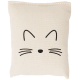 Un petit coussin de couleur crème présentant un design simple de visage de chat noir avec des oreilles pointues et des moustaches.