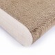 Nahaufnahme eines gebogenen Katzenkratzpads aus strukturiertem Karton, mit einer glatten Holzunterlage.