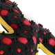 Close-up of a red and black rubber dog chew toy with spikes and yellow trim on a white background.