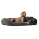 Ein entspannter grauer Weimaraner-Hund liegt auf einem plüschigen, runden grauen Hundebett.