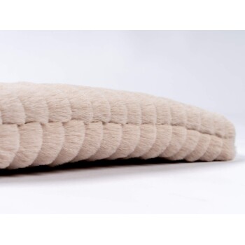 Eine Nahaufnahme eines weichen, beigen Haustierbettes mit einer strukturierten, plüschigen Oberfläche, das sein gemütliches Design und die abgerundeten Kanten zeigt.