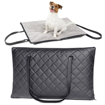 Ein glücklicher Hund sitzt auf einer weichen, grauen Haustiermatte mit Griffen, über einer stilvollen schwarzen, gesteppten Tragetasche.