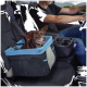 Ein glücklicher brauner Hund sitzt in einem blau-schwarzen Autositz für Haustiere, gesichert mit einem Sicherheitsgurt, während ein Mann in einem Fahrzeug fährt.