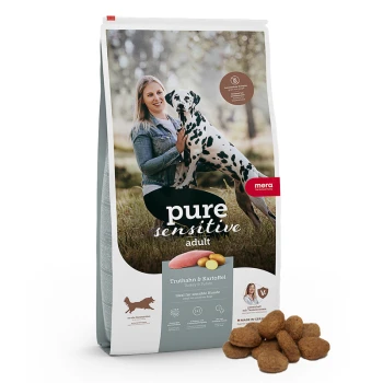 Eine Tüte "pure sensitive adult" Hundefutter mit Truthahn und Kartoffel, mit verstreuten Krokettenstücken davor.