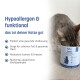 Getigerte Katze riecht an einem handgehaltenen 'KatKare' Beutel mit der Aufschrift 'Ente Essential' Enten-Snacks