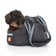 Ein kleiner, schwarz-brauner Hund schaut aus einer gemütlichen, grauen Tragetasche mit blauen Riemen, beschriftet mit 'Doctor Bark'.