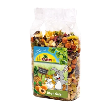 Eine durchsichtige Tüte mit buntem Haustierfruchtsalat, beschriftet mit "JR FARM Obst-Salat" mit einem Cartoon-Kaninchen und Hamster, das seine Vitamine hervorhebt.