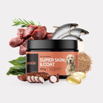 Hundesuperfood-Produkt mit der Aufschrift "SUPER SKIN & COAT" in einem schwarzen Glas, umgeben von Zutaten wie Fleisch, Fisch, Algen und Ergänzungen.