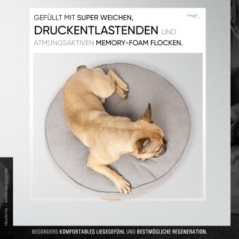 Eine Person öffnet einen grauen Bezug für ein Haustierbett mit dem Text: "WASCHBAR, KUSCHELWEICH & UNANFÄLLIG" und Waschhinweisen für 30 Grad.