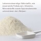 Ein Haufen weißes Pulver mit einem weißen Messlöffel daneben, begleitet von einem Text, der besagt, dass essentielle Nährstoffe Welpen unterstützen.