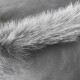 Nahaufnahme von weichem, flauschigem grauem Fell auf einer glatten Oberfläche, das die Textur und Details des Fells hervorhebt.