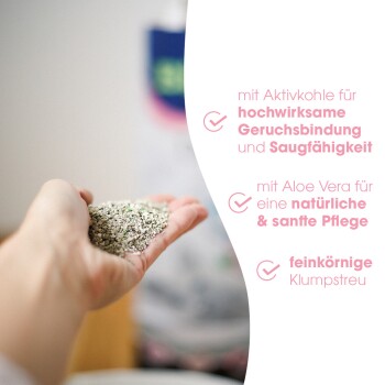 Eine Hand hält Katzenstreu mit Eigenschaften: "Aktivkohle zur Geruchskontrolle," "Aloe Vera für sanfte Pflege," und "feine Klumpen."