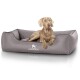 Ein hellgraues Hundebett mit einem gesteppten Design, mit dem Logo "KNUFFELWUFF" und einem Hund, der bequem darauf ruht.