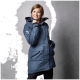 Eine Frau trägt eine blaue Outdoor-Jacke mit Kapuze, die zwei Fronttaschen und ein Logo am Ärmel hat, und posiert vor einem grauen Hintergrund.
