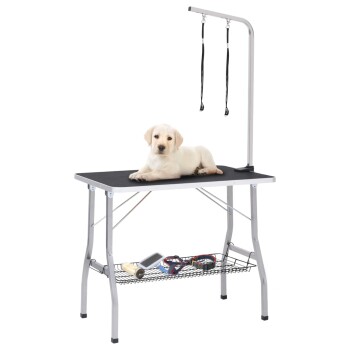 Ein hellfarbener Labrador-Welpe liegt auf einem Grooming-Tisch mit einem Grooming-Arm und Gurten, umgeben von Grooming-Werkzeugen auf einem unteren Regal.