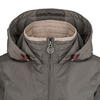 Eine Nahaufnahme einer grauen Haustierjacke mit hohem Kragen und Kapuze, mit einem Reißverschluss vorne und einem Logo am Reißverschluss.