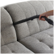 Eine Hand hält eine Staubsaugerdüse und reinigt ein graues, gepolstertes Sofa mit einem gepolsterten Design.