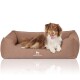 Ein glücklicher braun-weißer Hund liegt auf einem gemütlichen braunen Hundebett, mit dem Logo "KNUFFELWUFF" auf der Vorderseite sichtbar.