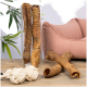 Eine Glasvase hält gedrehte Hundekauartikel, mit zwei weiteren auf einem Holztisch neben einem Seilspielzeug und einem rosa Haustierbett.