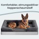 Deutscher Schäferhund auf grauem Hundebett mit erhöhtem Rand; Text oben: 'Komfortabler, atmungsaktiver Noppenschaumstoff'.