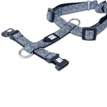 Schwarz-weißes Hundegeschirr mit geometrischem Muster, Kunststoffschnallen und Metall-D-Ringen, beschriftet mit "WAG MORE BARK LESS."