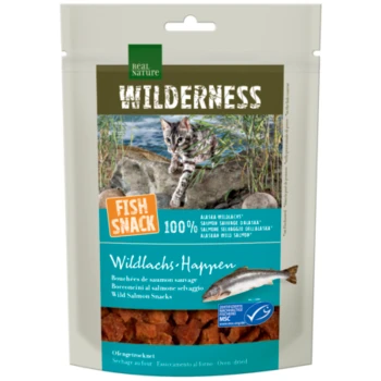 Real Nature Wilderness Fish Snack package with wild salmon treat for cats, featuring a playful cat on a rocky shore. Text: "100% ALASKA WILD SALMON."