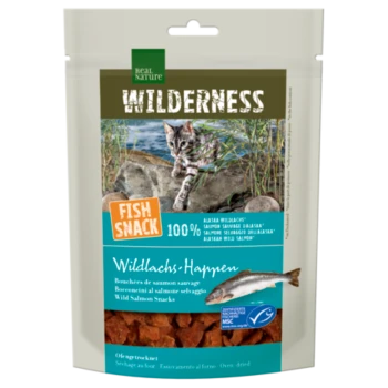Real Nature Wilderness Fish Snack verpakking met een wilde zalm traktatie voor katten, met een speelse kat op een rotsachtige kust. Tekst: "100% ALASKA WILD SALMON."
