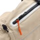 Nahaufnahme eines beigen Haustier-Rucksacks mit einem schwarzen Reißverschluss und einem orangefarbenen Ziehband, mit reflektierenden Details.