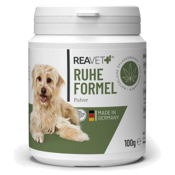 Behälter mit REAVET+ Ruhe Formel Pulver für Hunde, mit einem glücklichen Hund auf dem Etikett, mit "MADE IN GERMANY" und 100g Gewicht.